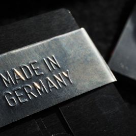 Zbliżenie metalowego szyldu z wytłoczonym napisem „MADE IN GERMANY”. 