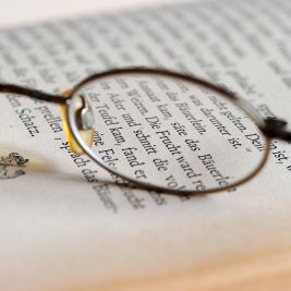 Eine Lesebrille liegt auf einem Buch, aufgenommen am 2.4.2012.