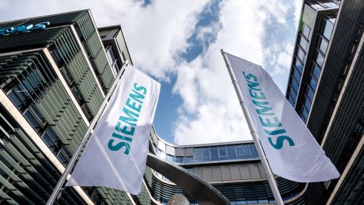 Der Schriftzug der Siemens AG ist auf Flaggen vor dem Firmensitz in München zu sehen. 