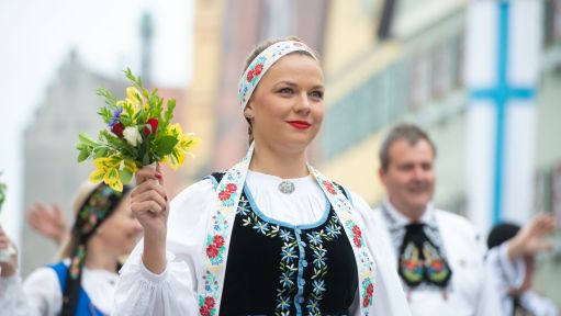 20.05.2018, Bayern, Dinkelsbühl: In traditioneller Tracht laufen Teilnehmer eines Trachtenumzuges anlässlich des Pfingsttreffens der Siebenbürger Sachsen durch die Altstadt von Dinkelsbühl. Foto: Timm Schamberger/dpa