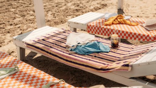 3 Strandliegen mit Strandtüchern darauf liegend