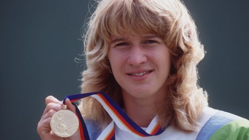Steffi Graf hält ihre Goldmedaille hoch.