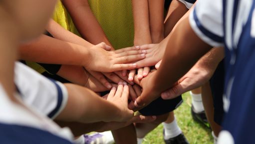 Kinder legen Hände übereinander zum Schwur