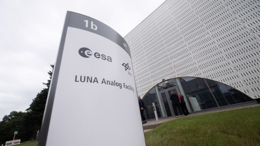 Trainingshalle mit Raumfahrtmodulen, im Hintergrund Banner von CSA, NASA und ESA.