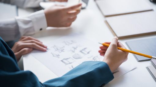 Eine Person, der verschiedene Designobjekte zeichnet.