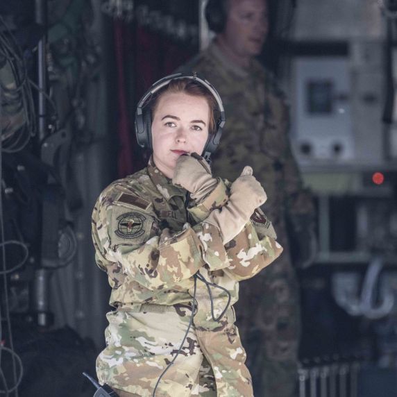 Eine Soldatin steht in der Öffnung eines Militärfliegers