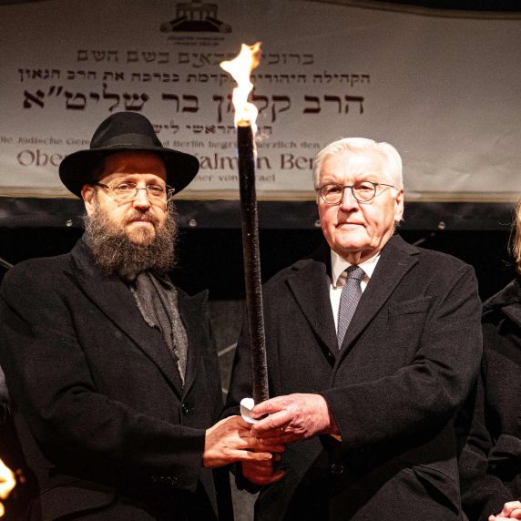 Rabbiner Yehuda Teichtal, Bundespräsident Frank-Walter Steinmeier und Elke Büdenbender entzünden am Sonntag die erste Chanukka-Kerze vor dem Brandenburger Tor. 