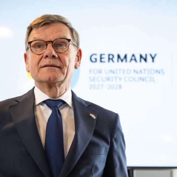 Ein Mann steht vor einer Leinwand, darauf steht „Germany for UN Security Council 2027/2028“.