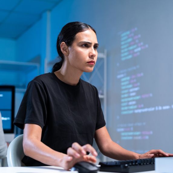 Eine junge Frau betrachtet konzentriert einen Computerbildschirm.