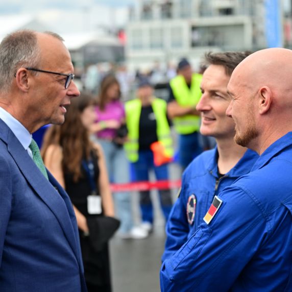 Bundeskanzler Friedrich Merz (l.) mit den ESA-Astronauten Matthias Maurer und Alexander Gerst (r.) auf der ILA in Berlin 