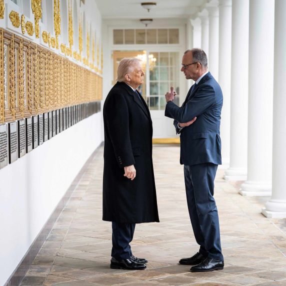 Trump und Merz stehen in einem Gang bei einem Treffen in Washington 