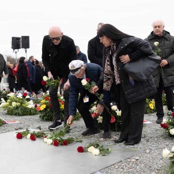 Der Holocaust-Überlebende Andrei Moiseenko aus Belarus legt Rosen nieder.