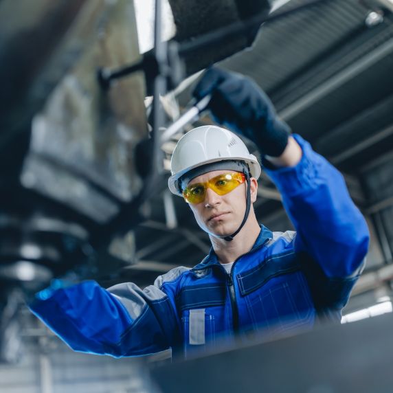 Ein Arbeiter an einer Bedienungsmaschine in der industriellen Werkstatt