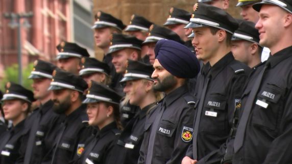 Mehrere junge Männer und Frauen in Polizeiuniform stehen auf  einer Treppe. Einer der Männer trägt einen Turban.