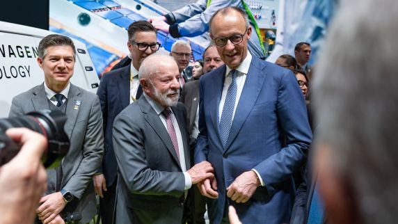 Mehrere Männer stehen an einem Messestand.
