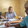 Zwei Menschen in einem Büro in Nigeria bearbeiten Anträge