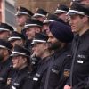 Mehrere junge Männer und Frauen in Polizeiuniform stehen auf  einer Treppe. Einer der Männer trägt einen Turban.
