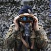 Ein Soldat der Bundeswehr blickt durch ein Fernglas. 