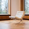 Barcelona-Sessel von Ludwig Mies van der Rohe und Lilly Reich aus dem Jahr 1929 steht in einem Raum mit Parkett und großen Fenstern.