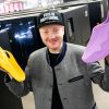 Ein junger Mann hält zwei Schuhe aus dem 3D-Drucker 