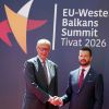 Bundeskanzler Friedrich Merz und Jakov Milatovic, Präsident von Montenegro, geben sich die Hand. Sie stehen vor einem Plakat mit der Aufschrift „EU Western Balkans Summit Tivat 2026“. 