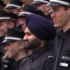 Mehrere junge Männer und Frauen in Polizeiuniform stehen auf  einer Treppe. Einer der Männer trägt einen Turban.