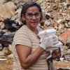 Eine Frau mit Essenspaketen vor einer Trümmerlandschaft 