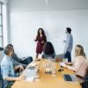 Personen sitzen und stehen in einem Büro.