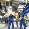 Arbeiter montieren und bauen Gasturbinen in einer modernen Industriefabrik