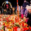Menschen zollen den Opfern mit Blumen und Kerzen ihren Respekt.