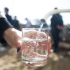 Wasser fließt aus einem Hahn in ein Glas.