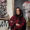 Graffiti-Künstlerin Hera vor einer Wand mit ihrer Kunst