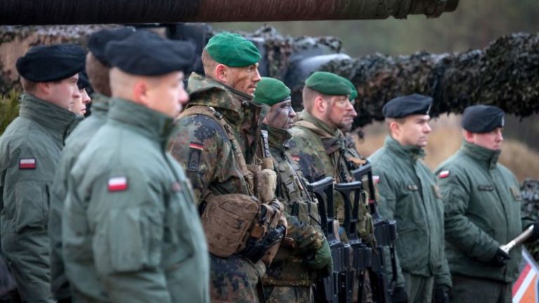 Deutsche und polnische Soldaten stehen in Reihe nebeneinander