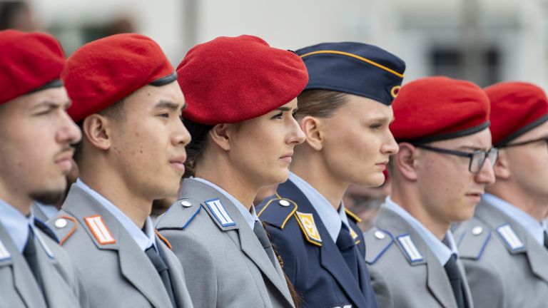Soldaten und Soldatinnen stehen in einer Reihe.