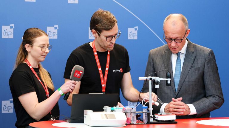 Bundeskanzler Merz lässt sich von Forschenden ihre Arbeit erklären. 