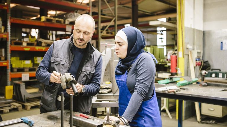 Ein Mann und eine Frau mit Migrationshintergrund in der Wertkstatt