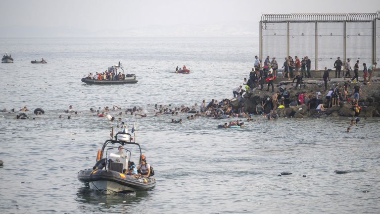 Menschen schwimmen über das Meer zu einem Felsen